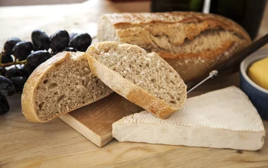 Crédence de cuisine en verre imprimé Entrée Crusty bread slices with brie cheese and grapes, focus on edge of bread.