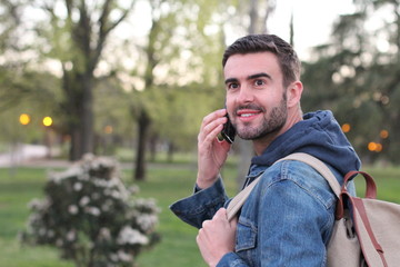 Man calling by phone outdoors and looking away