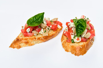 Two bruschettes with cheese Feta, basil and meat pieces