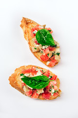 Two bruschettes with cheese Feta, basil and meat pieces