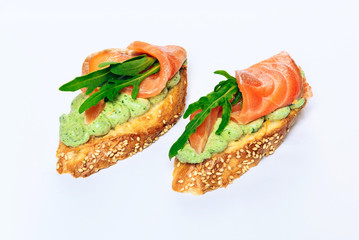 Two bruschettes with arugula in fillet of tuna and green sauce