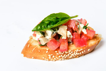 Bruschetta with cheese Feta, basil and meat pieces