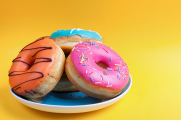 Plate set of donuts in the glaze on an orange background