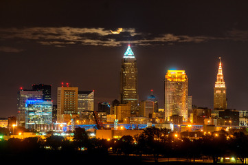Obraz premium Rising full moon above Cleveland Ohio shining through clouds