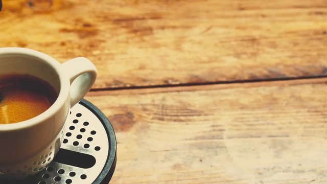 pour coffee with coffee maker in a white cup on a wooden floor in the kitchen at the breakfast