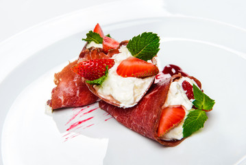 Strawberry and mint in white cream covered with sliced jamon.