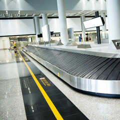 suitcases on conveyor belt of airport.