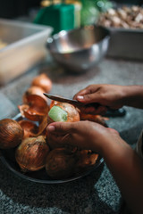 Close up of woman hands peelling the onion, preparation for cooking