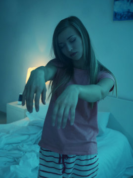 Young sleepy woman suffering from somnambulism at home