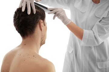 Dermatologist examining patient in clinic