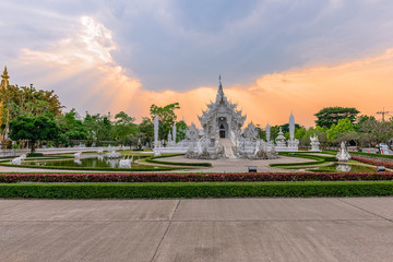 Fototapeta na wymiar Wat Rong Khun()at sunset in Chiang Rai,Thailand.03/04/2017 Wat Rong Khun is modern building, well known worldwide.It was designed by Chalermchai Kositpipat.