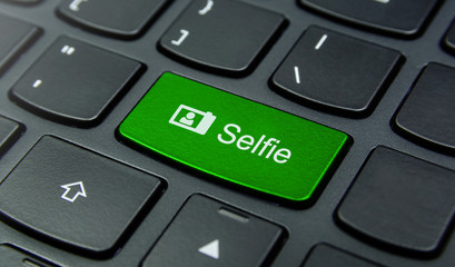 Close-up the Selfie button on the keyboard and have Green color button isolate black keyboard