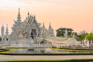 Fototapeta premium Wat Rong Khun()at sunset in Chiang Rai,Thailand.03/04/2017 Wat Rong Khun is modern building, well known worldwide.It was designed by Chalermchai Kositpipat.