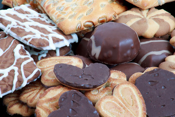Marshmallow and chocolate chip cookies lie on a black plate.