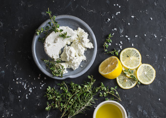 Making feta cheese, olive oil and thyme dip or sauce. On dark background, top view