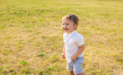 Portrait of smiling happy baby boy on natural background in summer