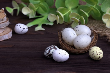 Easter decoration with Easter eggs in the nest burlap cloth green branches.