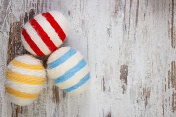 Easter eggs wrapped woolen string on wooden background, copy space for text, decoration for Easter