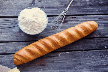 Delicious french baguette on a grey wooden table.