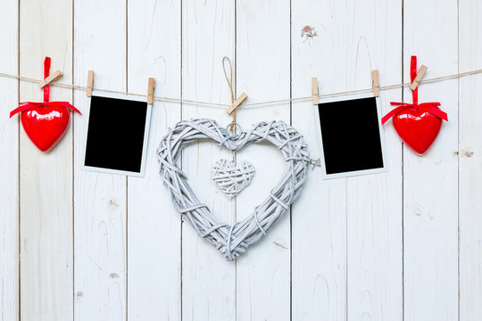 wooden rustic decorative hearts and photo frame hanging on vintage wooden background with space.
