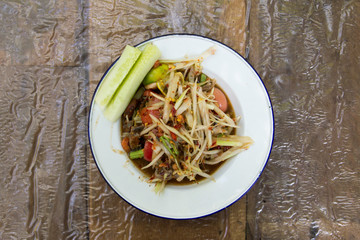 Thai papaya salad (Somtum) on wooden background