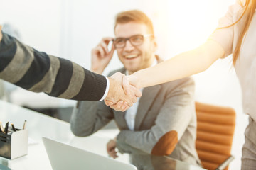 handshake of business partners on the background of the professional employee
