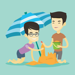 Two friends building sandcastle on beach.