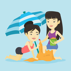 Two friends building sandcastle on beach.