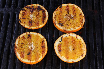 Fresh cut orange slices on a BBQ with grill marks