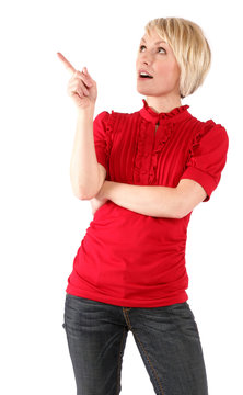Woman with short blonde hair and a red shirt is pointing with a curious expression.