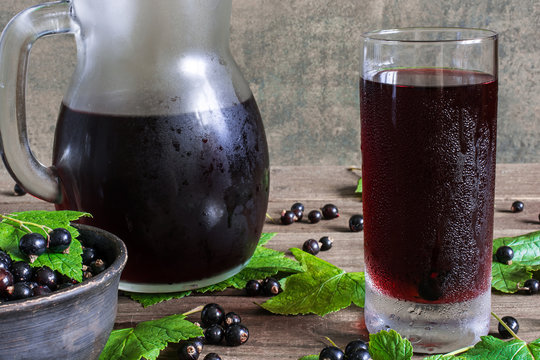 cold black currant juice in a glass and pitcher