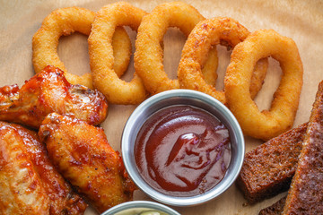 Snack from chicken wings and squid rings and bread