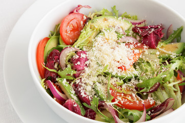 fresh vegetable salad with oil  and vinegar dressing sprinkled with parmesan