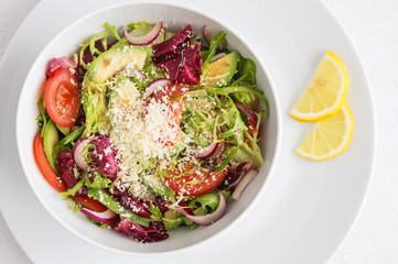 salad of romano, frisse, and radiccho leafs with tomato, onion, and avocado 