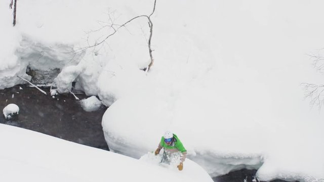 Snowboarder Dangerous Jump Over River in Deep Powder Snow Japanese Mountains