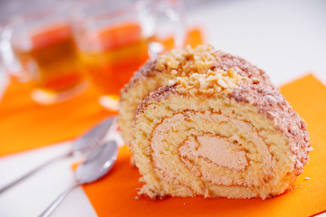 Slice of sweet cream roll and metal spoons