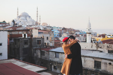 Couple in love on roof in old city Istanbul. Beautiful mosque view on background