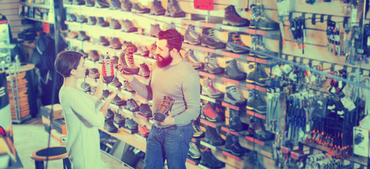 Smiling young couple examining various shoes