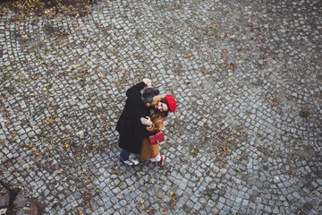 Fototapeta na wymiar Сouple embracing in an old european street with paving stones, top view