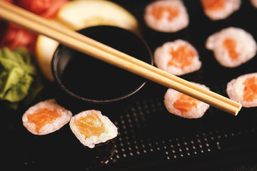 Sushi rolls with salmon, soy sauce and chopsticks