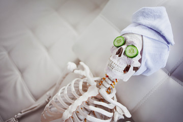 Skeleton in Spa salon with towel on her head and mask on her face, relaxes, care themselves. An...