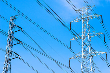 the electricity transmission pylon silhouetted against blue sky