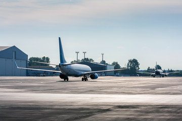 Planes taxiing one after another in backlit