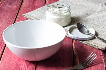 vintage wooden kitchen table with an empty bowl of soup and sour cream