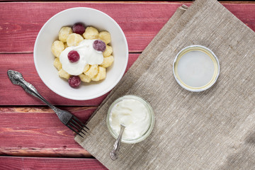 Traditional russian, ukrainian cottage cheese lazy dumplings served with sour cream and cherry