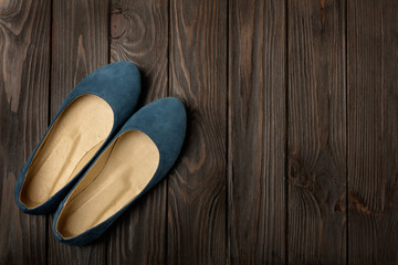 Blue women's shoes (ballerinas) on wooden background.