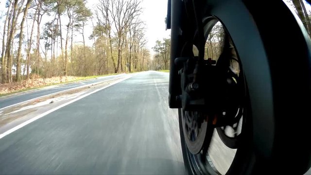 Timelapse of low angle point of view of motor driving with front tire in picture