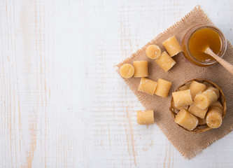 Coconut sugar and sugar syrup in glass bowl on wood