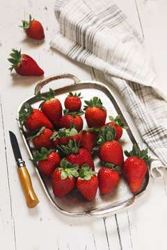 Fototapeta Strawberries in spring on silver plate over white wooden