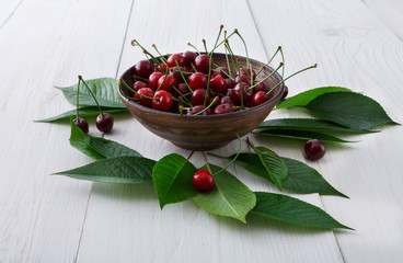 Sweet fresh cherries on white wood background